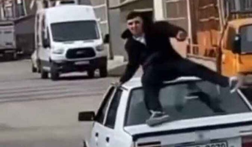 Hareket halindeki otomobilin tavanındaki yolculuk kötü bitti: Sırt üstü yere çakıldı